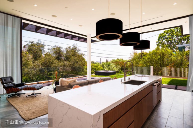 03-The-kitchen-is-decorated-in-light-colored-warm-wood-marble-surfaces-and-can-be-partly-opened-to-outdoors-775x514.jpg