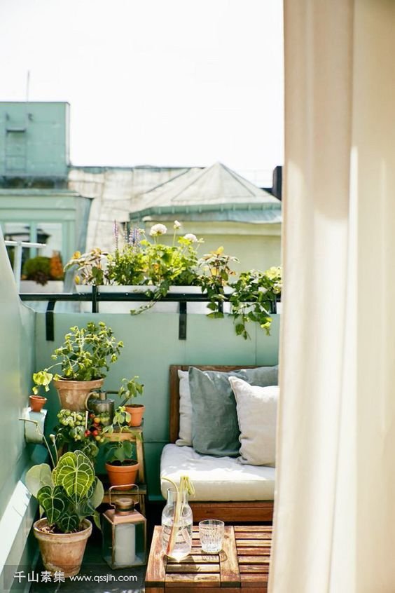 24-a-very-small-balcony-with-a-wooden-crate-as-a-table-an-upholstered-bench-a-ladder-and-lots-of-potted-greenery.jpg