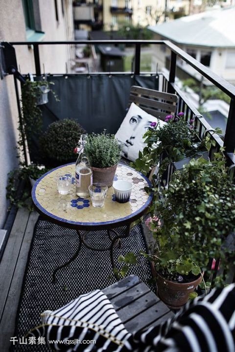 19-a-monochromatic-balcony-with-chairs-and-a-lot-of-potted-greenery-is-spruced-up-with-a-colorful-mosaiic-table.jpg