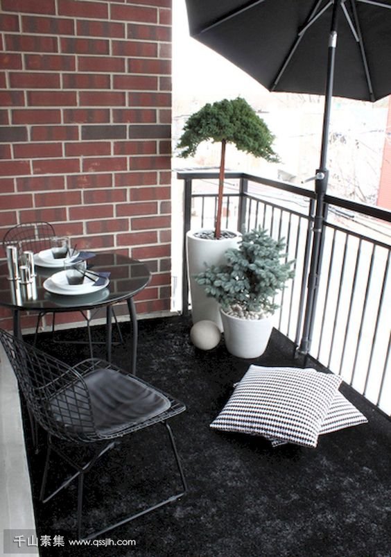 03-a-black-rug-a-metal-dining-set-potted-plants-and-a-large-umbrella-for-privacy-and-to-protect-from-the-sun.jpg